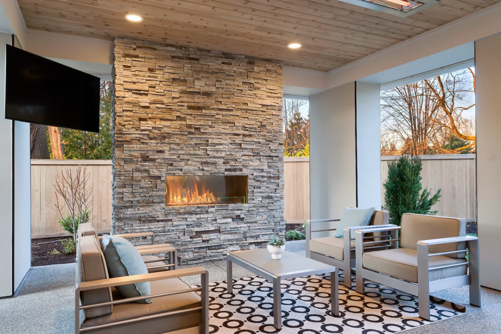 A renovated residential patio with a 3-season sunroom and stone finishes. | S&S Remodeling