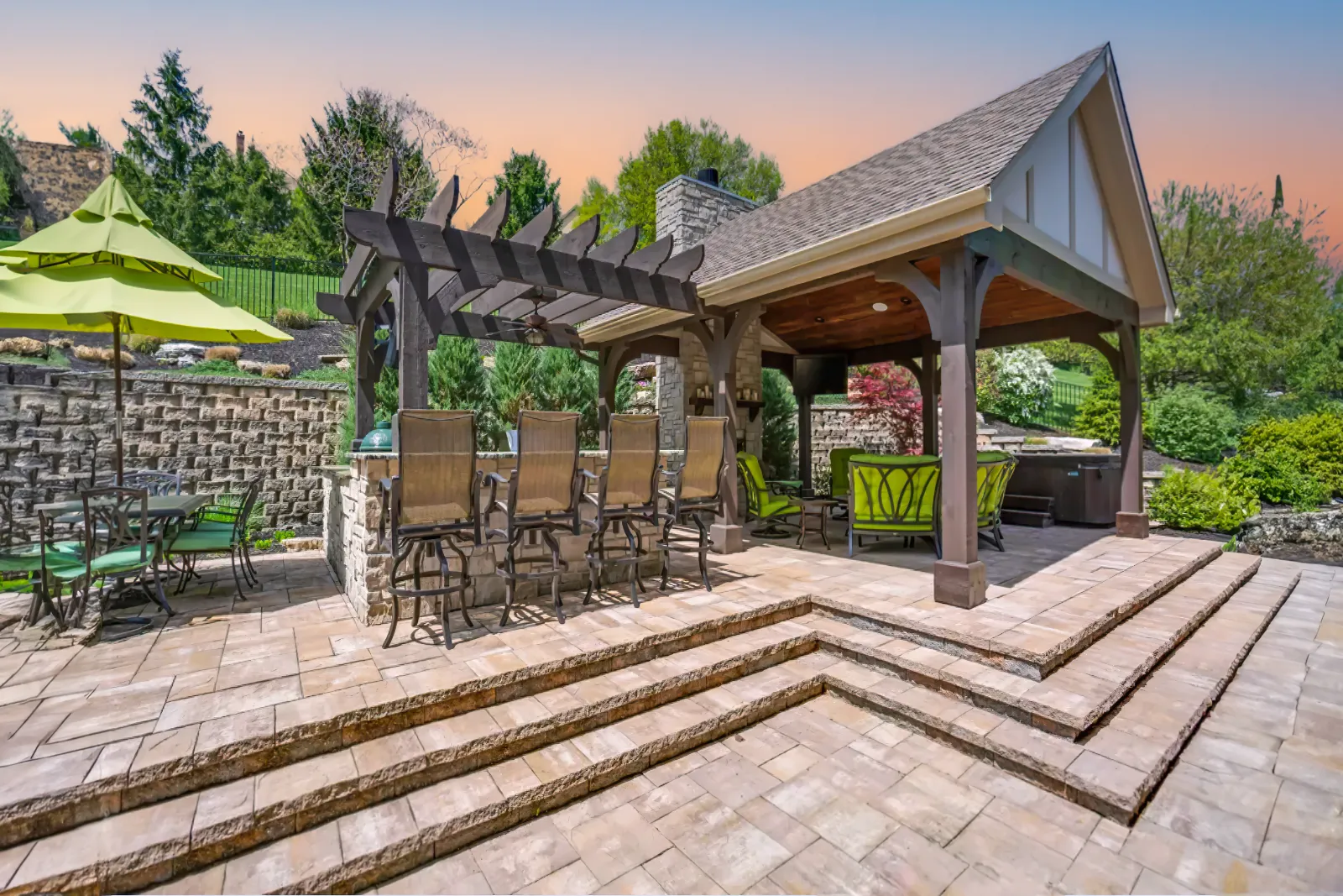 Patio with pergola, awning, and stone in a residential outdoor living space. | S&S Remodeling